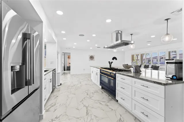 a large kitchen with stainless steel appliances lots of counter space and wooden floor