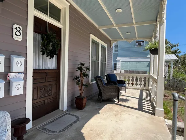an empty room with wooden floor chandelier fan and windows