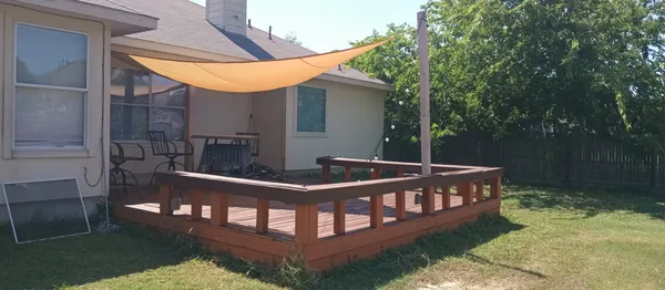 a view of a wooden deck and a yard