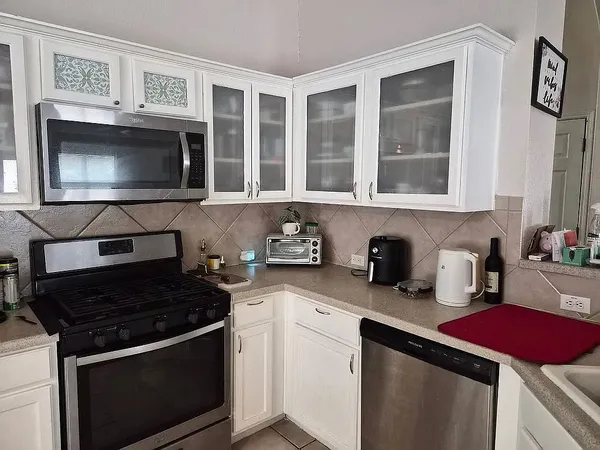 a kitchen with stainless steel appliances granite countertop a stove and a microwave