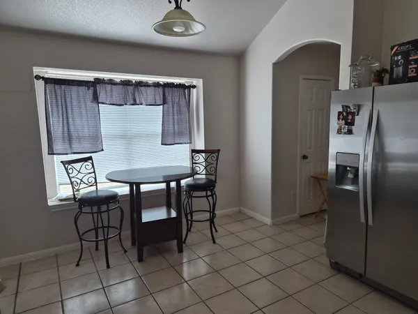 a view of kitchen with furniture and refrigerator