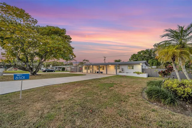 a palm tree sitting in front of a house with a yard
