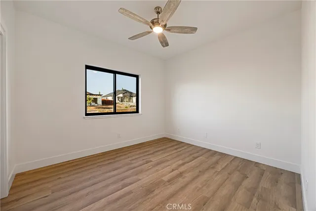 an empty room with a window and a fan
