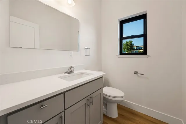 a bathroom with a granite countertop sink a toilet and a mirror