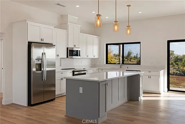 a kitchen with stainless steel appliances granite countertop a refrigerator a stove a sink and a refrigerator