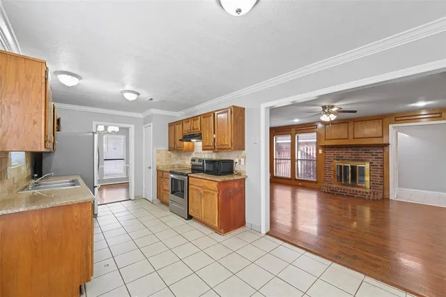 a kitchen with stainless steel appliances granite countertop a stove top oven a sink a counter space and cabinets