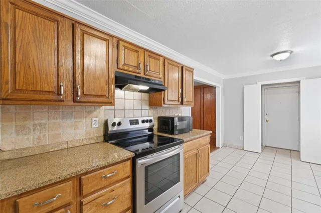 a kitchen with stainless steel appliances granite countertop a stove a sink and a microwave