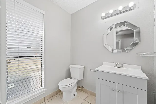 a bathroom with a toilet a sink a vanity and mirror