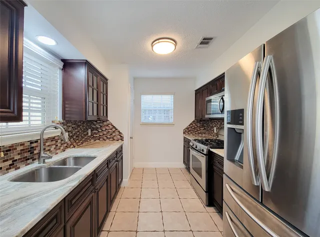 a kitchen with stainless steel appliances granite countertop a sink stove and refrigerator