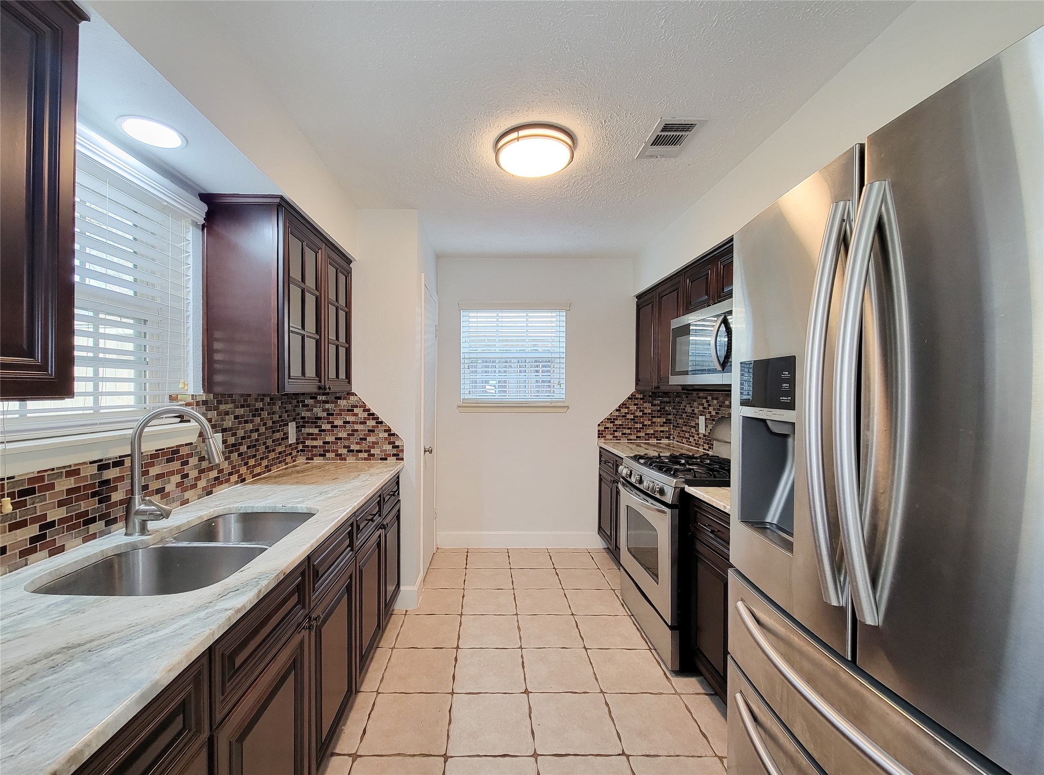 3434 Almondwood Drive Spring, TX 77389 - Photo 11 of 37 a kitchen with stainless steel appliances granite countertop a sink stove and refrigerator