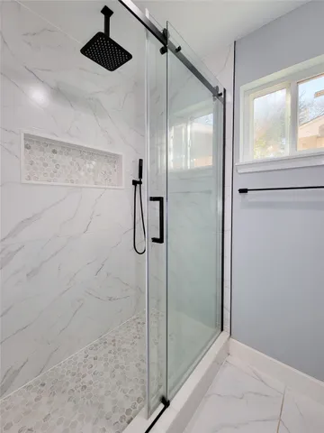 a bathroom with a shower and a glass door