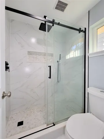 a bathroom that has a glass shower door