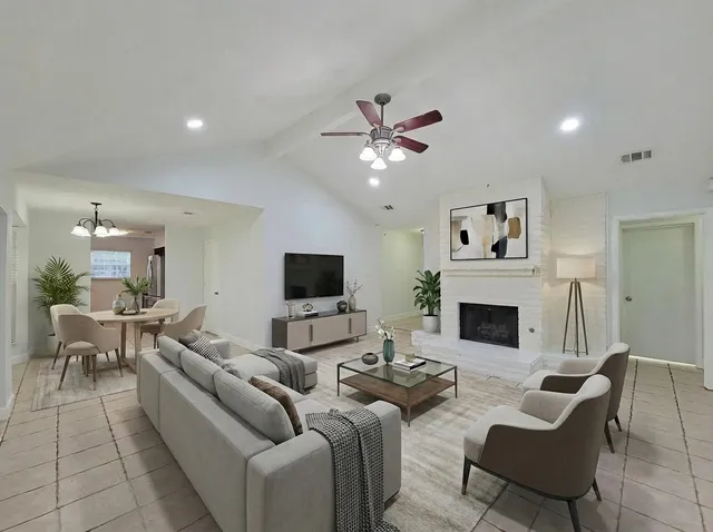 a living room with furniture a fireplace and a flat screen tv