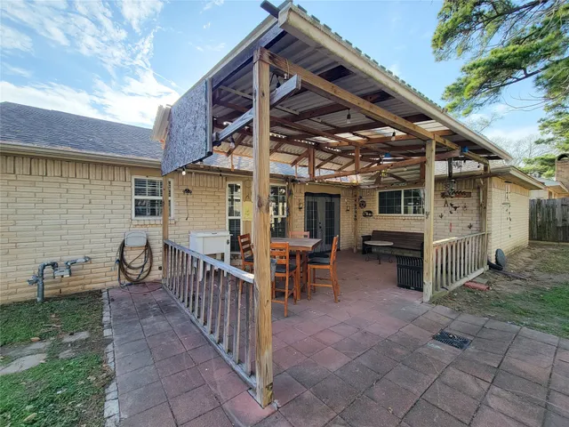 a view of a patio with table and chairs with wooden fence and plants