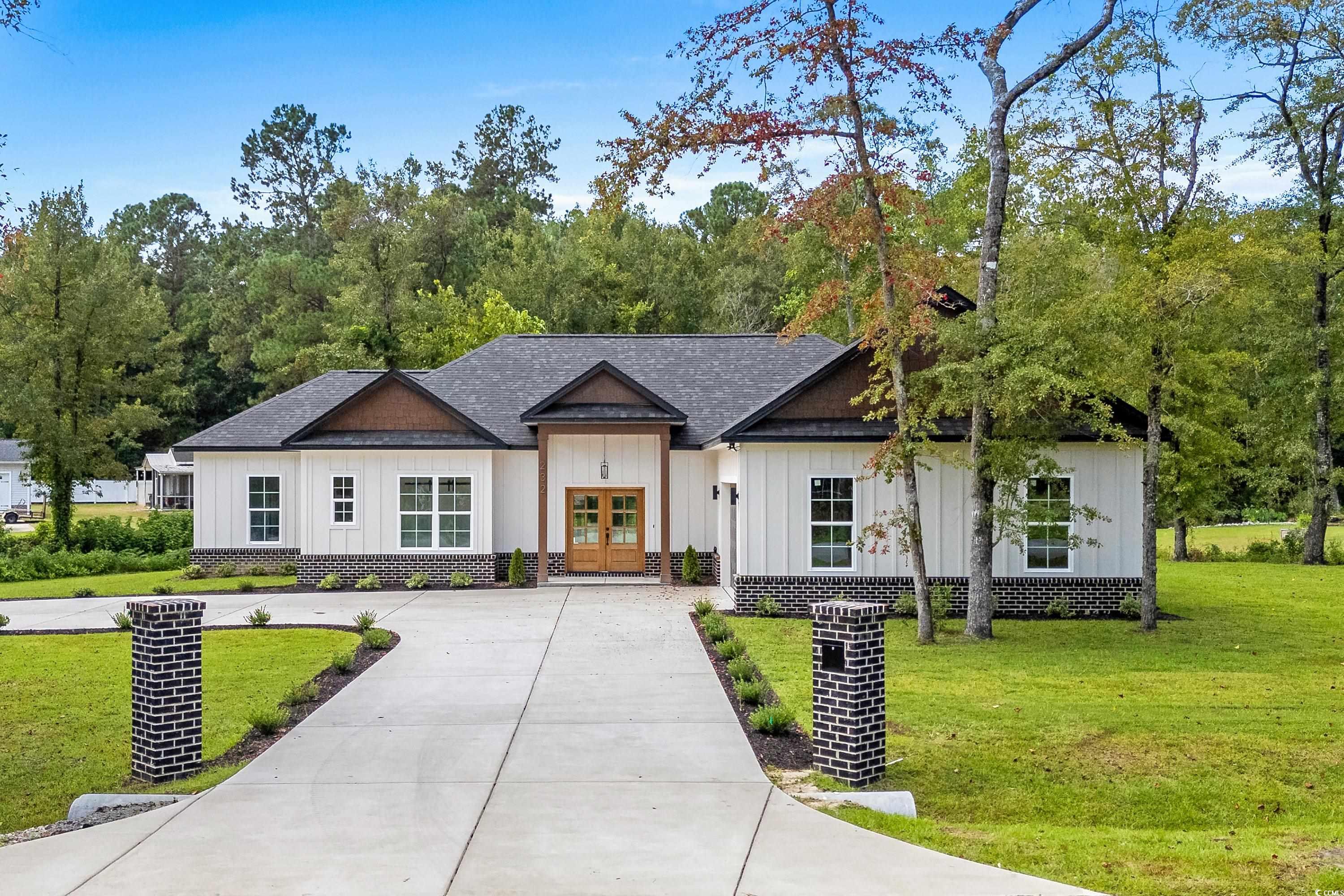 232 Ole Maple Street Loris, SC 29569 - Photo 1 of 40 Modern inspired farmhouse with board and batten siding, a front lawn, driveway, french doors, and a shingled roof