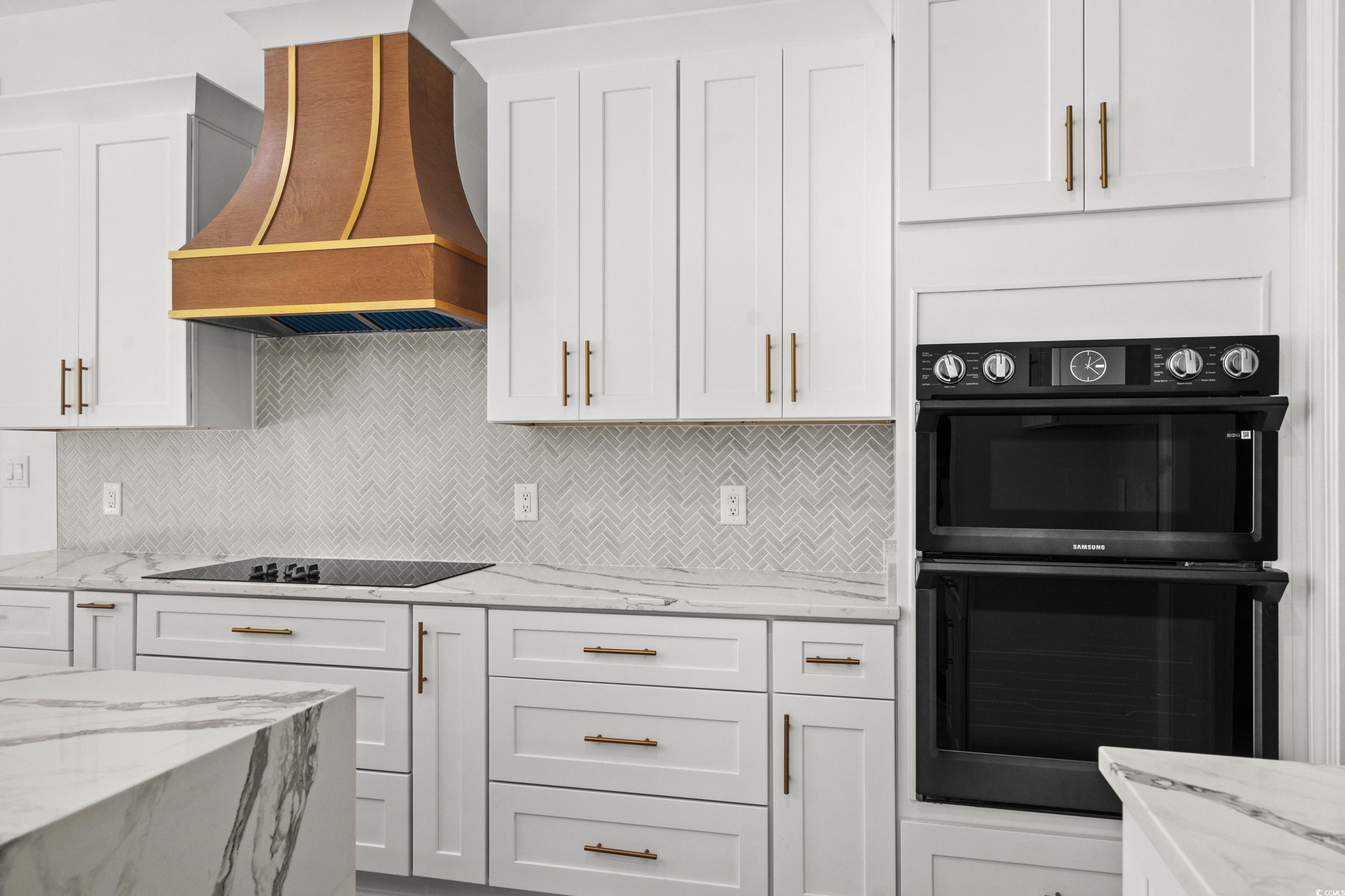 232 Ole Maple Street Loris, SC 29569 - Photo 10 of 40 Kitchen featuring light stone countertops, backsplash, custom exhaust hood, and white cabinets