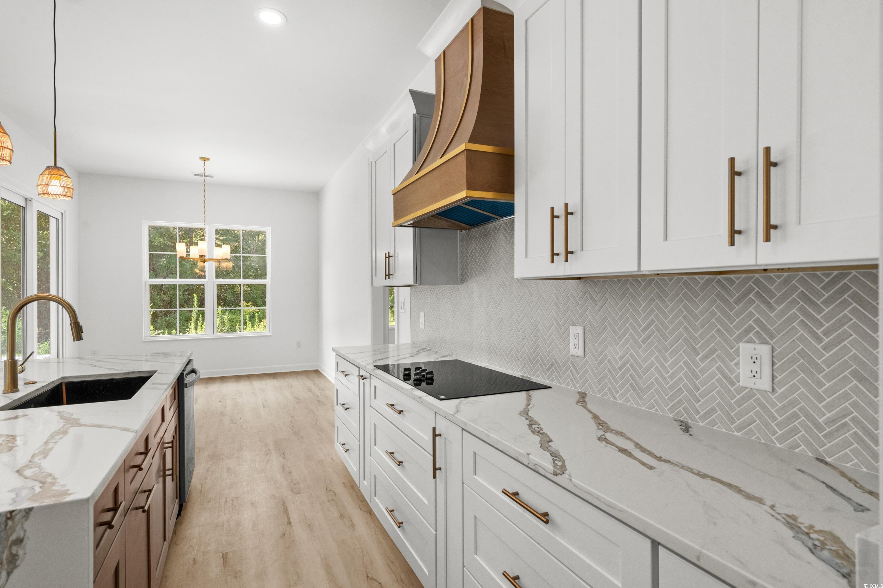 232 Ole Maple Street Loris, SC 29569 - Photo 11 of 40 Kitchen featuring light stone counters, tasteful backsplash, white cabinets, decorative light fixtures, and custom range hood