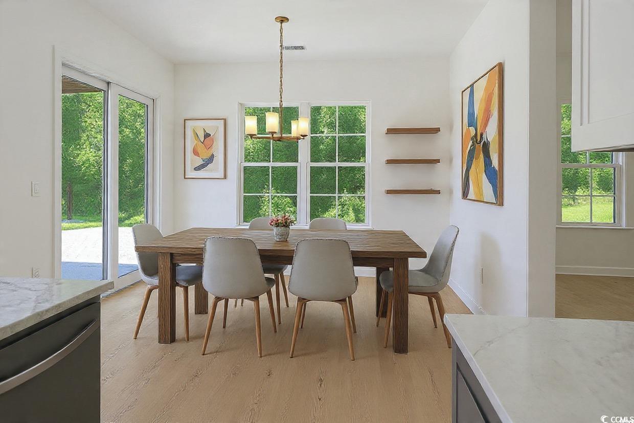 232 Ole Maple Street Loris, SC 29569 - Photo 13 of 39 Dining space featuring plenty of natural light, a chandelier, and light wood-style flooring