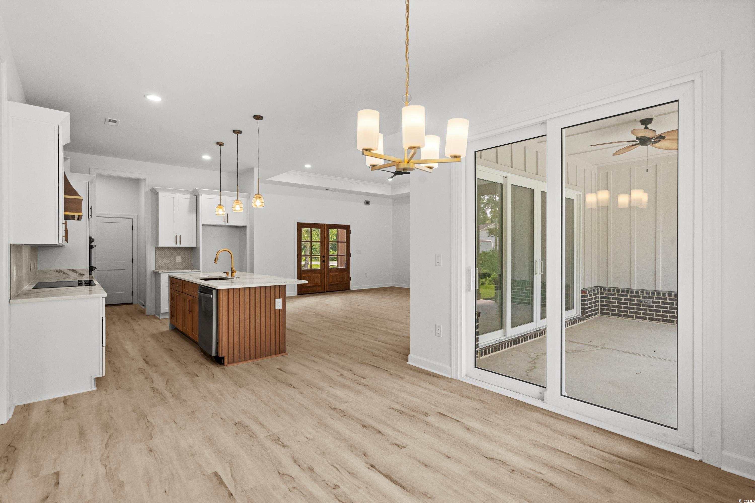 232 Ole Maple Street Loris, SC 29569 - Photo 40 of 40 Kitchen featuring open floor plan, a center island with sink, white cabinets, decorative light fixtures, and backsplash