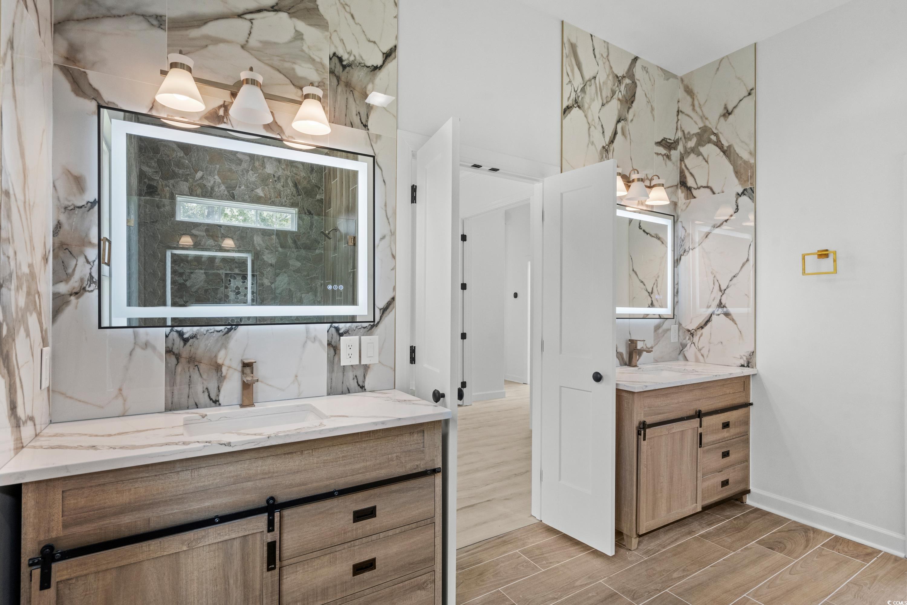 232 Ole Maple Street Loris, SC 29569 - Photo 21 of 40 Bathroom featuring two vanities, wood tiled floors, and stone wall
