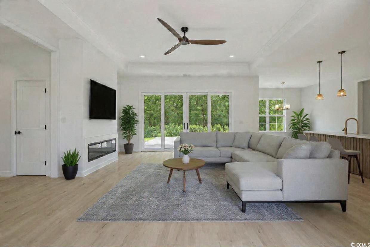 232 Ole Maple Street Loris, SC 29569 - Photo 4 of 39 Living area with a ceiling fan, light wood-style flooring, a glass covered fireplace, a chandelier, and recessed lighting