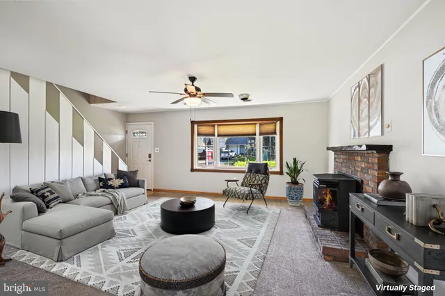 a living room with furniture kitchen view and a window