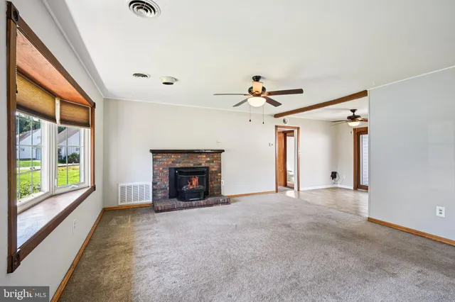 a view of an empty room with a fireplace and a window