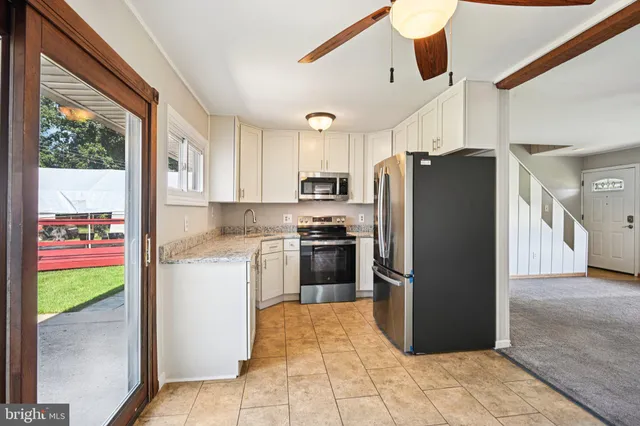 a kitchen with stainless steel appliances granite countertop a refrigerator and a stove