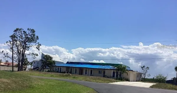 a view of a house with a big yard and large trees
