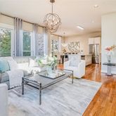 a living room with furniture dining table and a chandelier