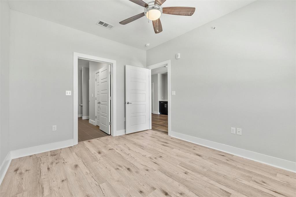 3114 South Congress Avenue, Unit 302 Austin, TX 78704 - Photo 19 of 28 an empty room with wooden floor fan and windows