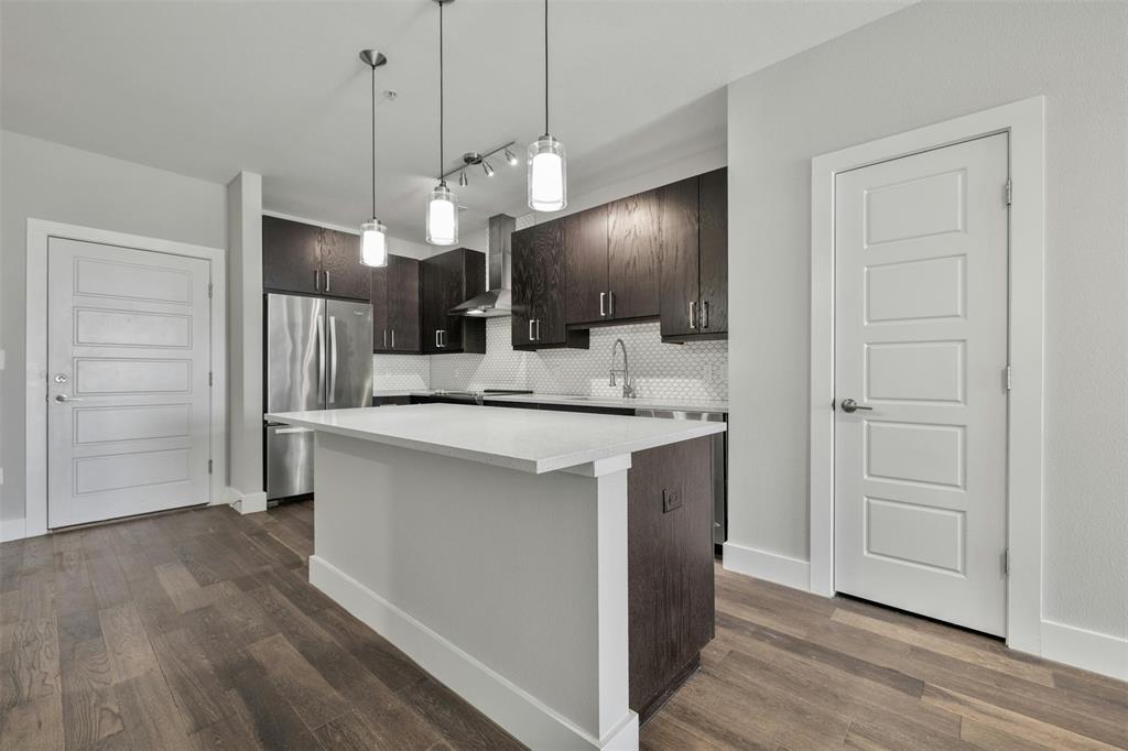 3114 South Congress Avenue, Unit 302 Austin, TX 78704 - Photo 2 of 28 a kitchen with kitchen island white cabinets and stainless steel appliances