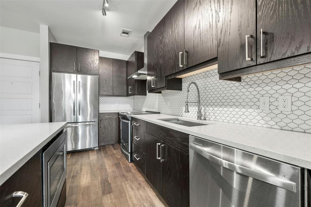 3114 South Congress Avenue, Unit 302 Austin, TX 78704 - Photo 6 of 28 a kitchen with stainless steel appliances granite countertop a sink stove and refrigerator