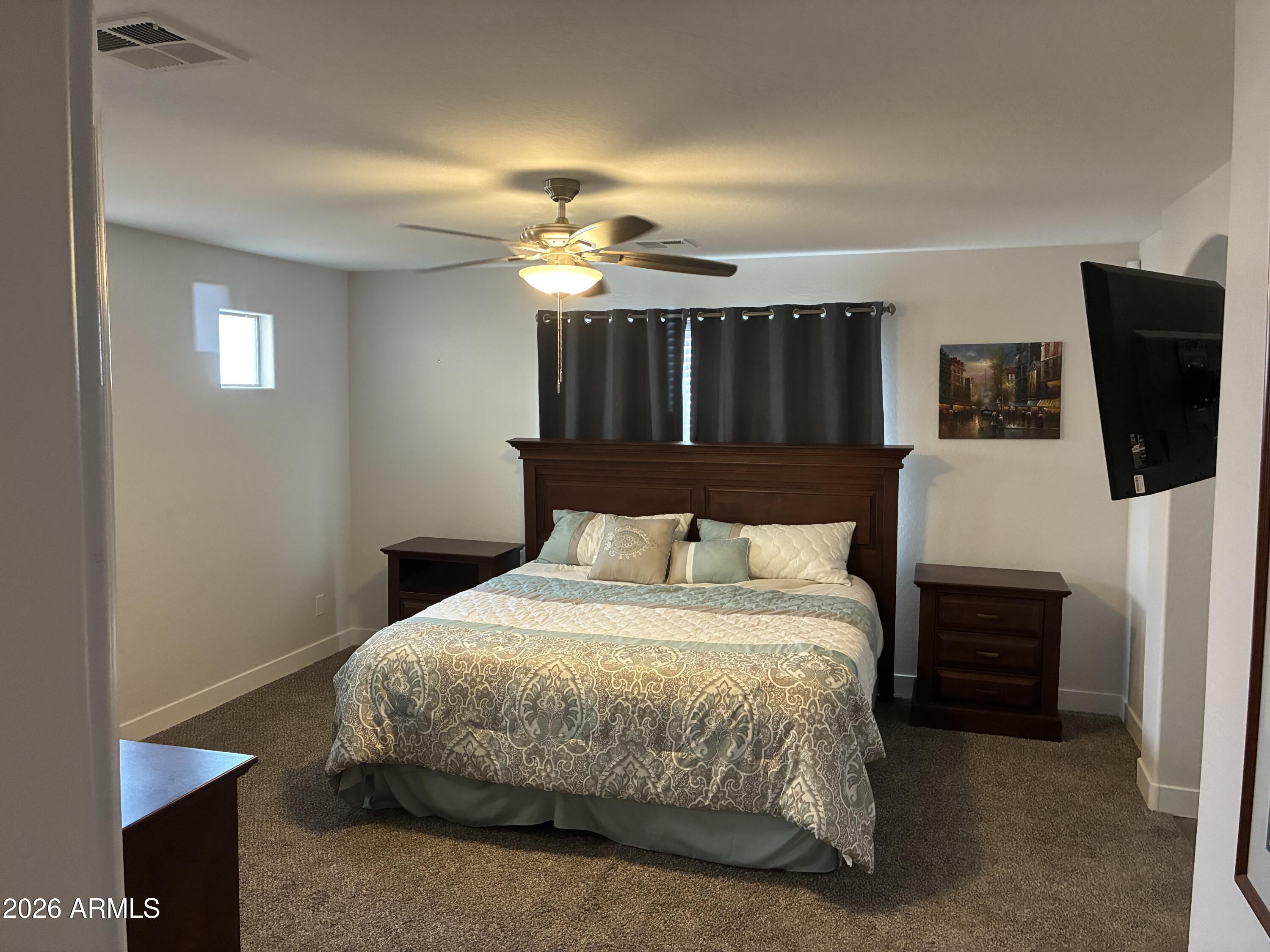 4634 West Fremont Rd. Laveen, AZ 85339 - Photo 20 of 46 a bedroom with a bed a dresser and a chandelier