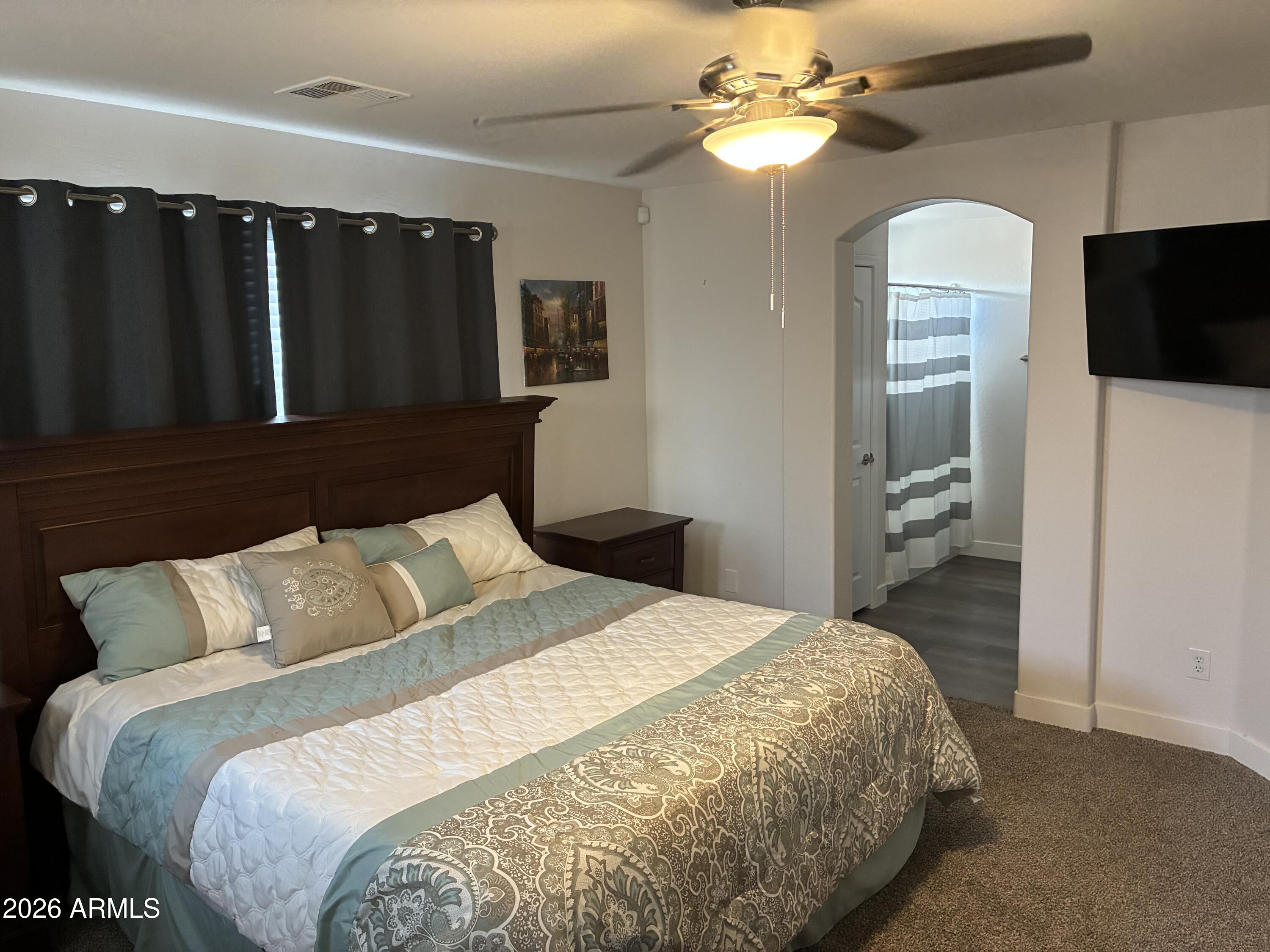 4634 West Fremont Rd. Laveen, AZ 85339 - Photo 21 of 46 a bedroom with a bed and a chandelier