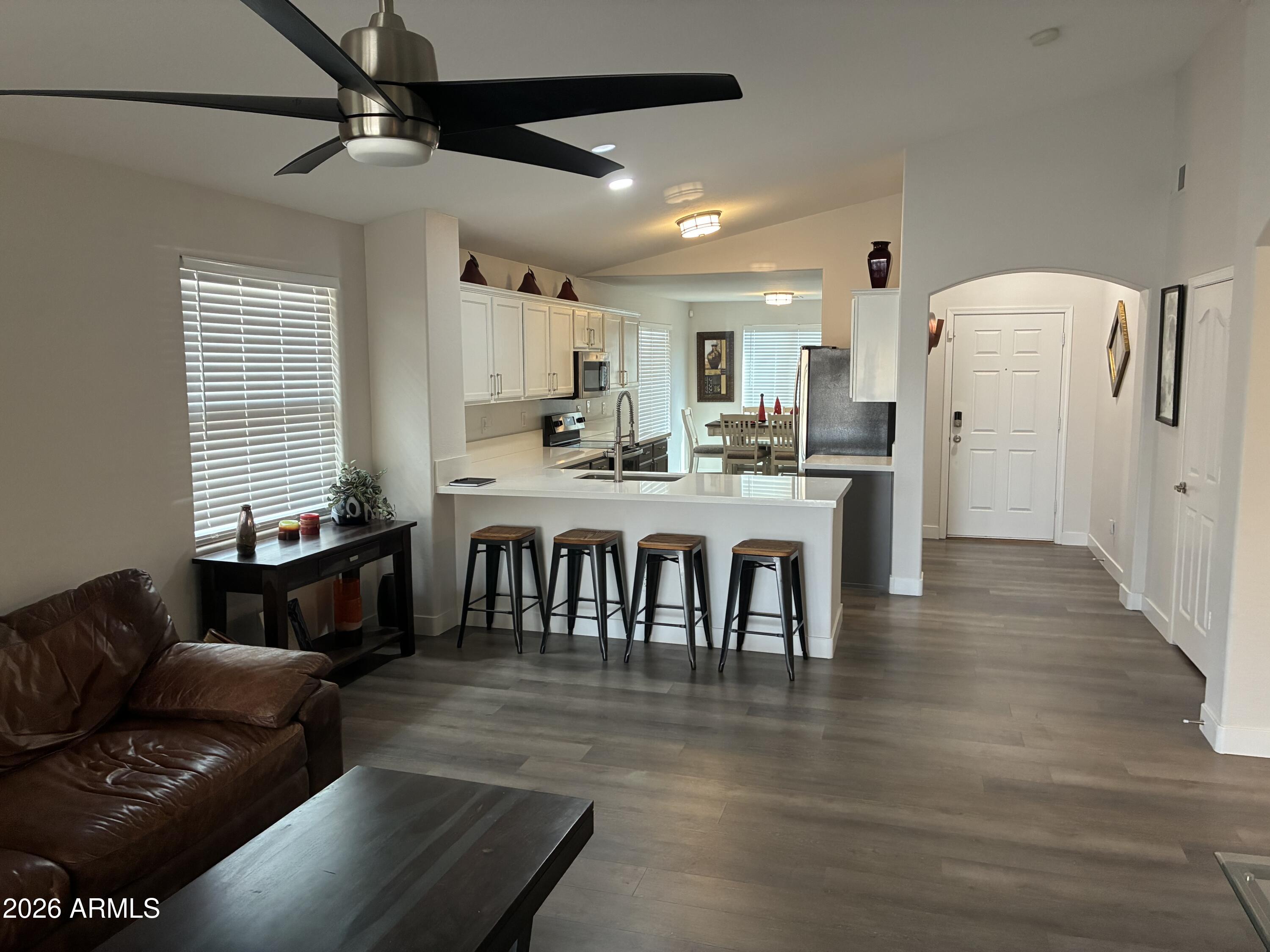 4634 West Fremont Rd. Laveen, AZ 85339 - Photo 9 of 46 a dining hall with stainless steel appliances granite countertop a stove a refrigerator a dining table and chairs with wooden floor