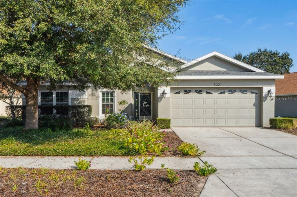 322 Greenwich Circle Spring Hill, FL 34609 - Photo 1 of 1 a front view of a house with a garden and plants