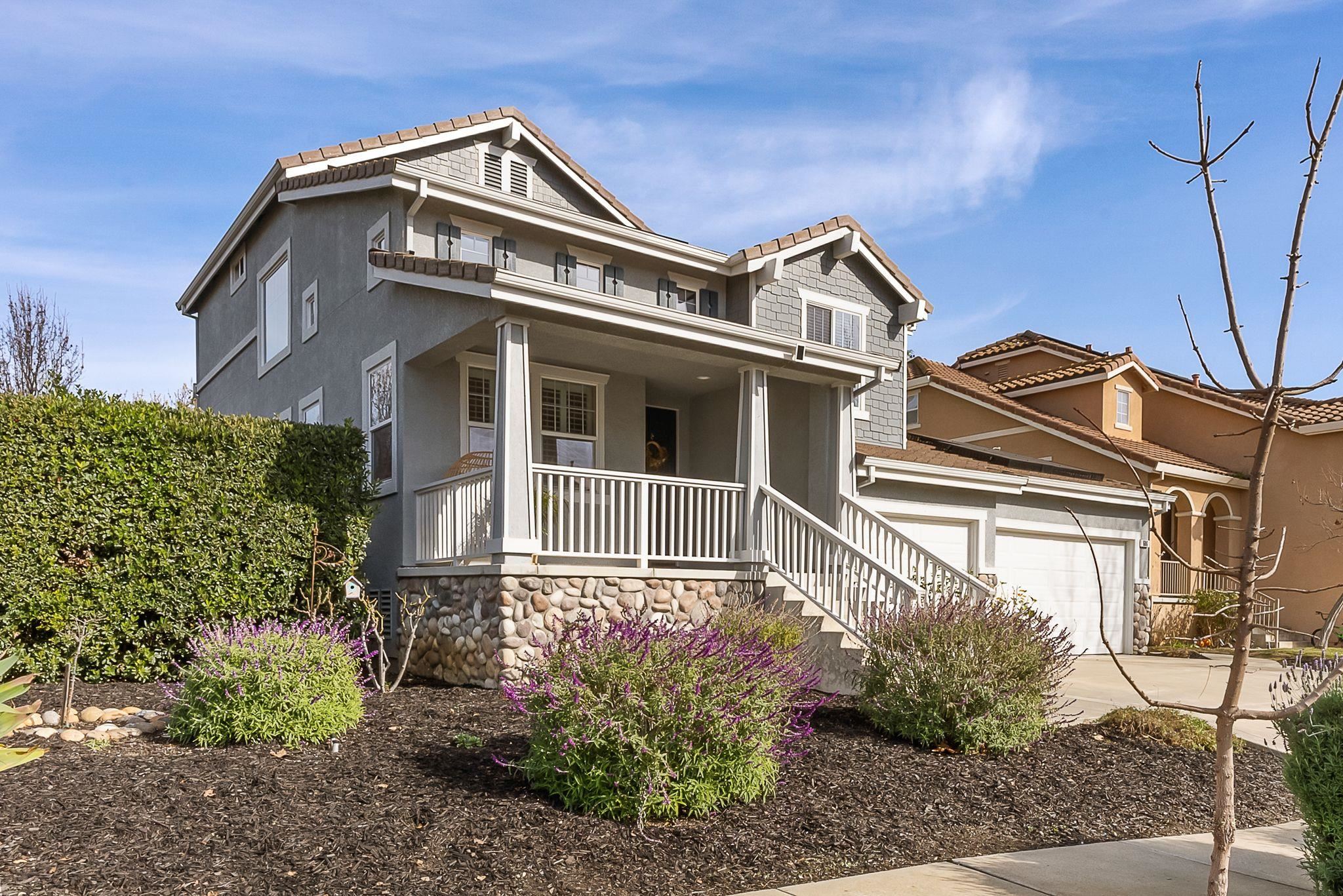 View of front of home featuring a porch, stucco siding, and concrete driveway