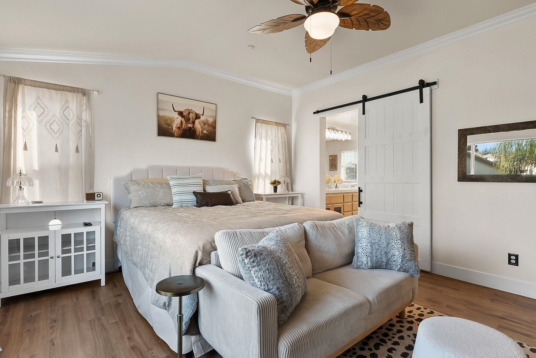 606 Ralston Court Brentwood, CA 94513 - Photo 17 of 32 Bedroom featuring a barn door, ensuite bath, wood finished floors, a ceiling fan, and crown molding