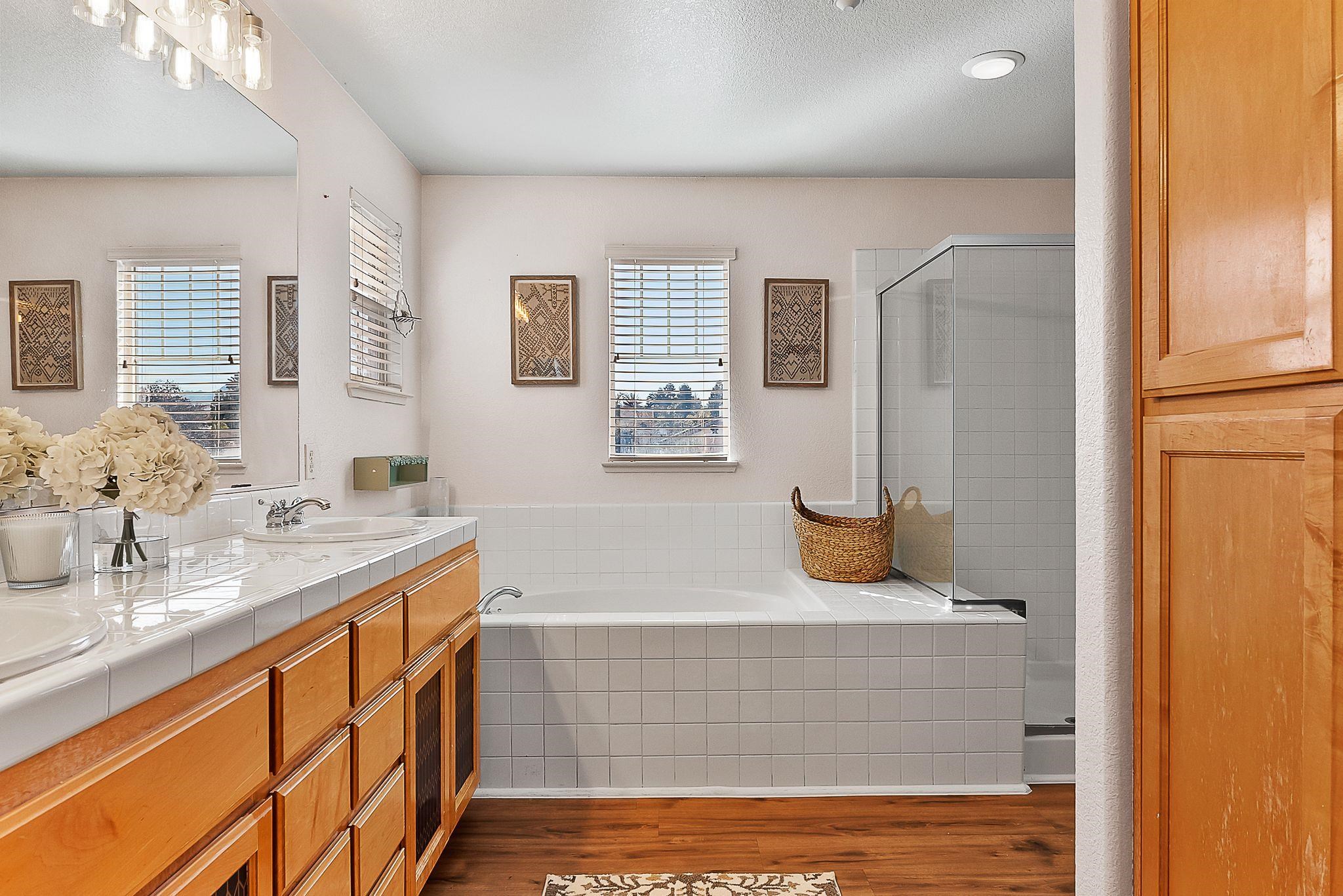 606 Ralston Court Brentwood, CA 94513 - Photo 20 of 32 Bathroom featuring a garden tub, double vanity, a shower stall, and wood finished floors
