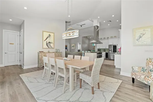 a kitchen with stainless steel appliances granite countertop a stove top oven a refrigerator a sink and a dining table view