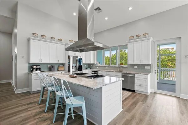 a kitchen with stainless steel appliances granite countertop a stove and a wooden floors