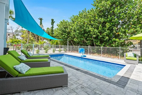 a view of a house with a swimming pool and sitting area