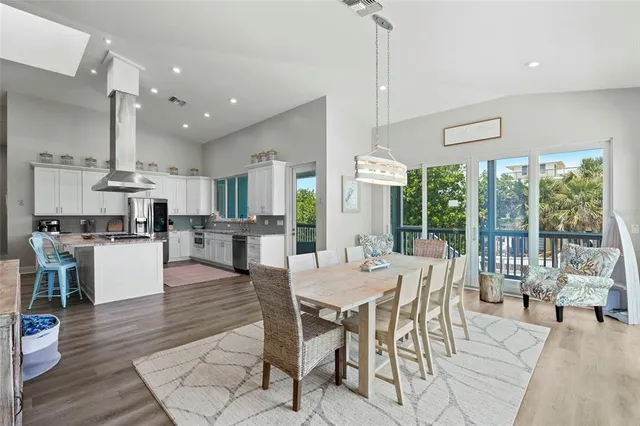 a view of a dining room and livingroom with furniture wooden floor a chandelier