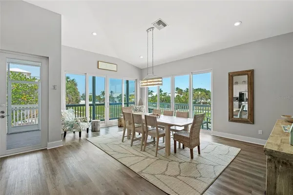 a view of a dining room and livingroom with furniture wooden floor kitchen view