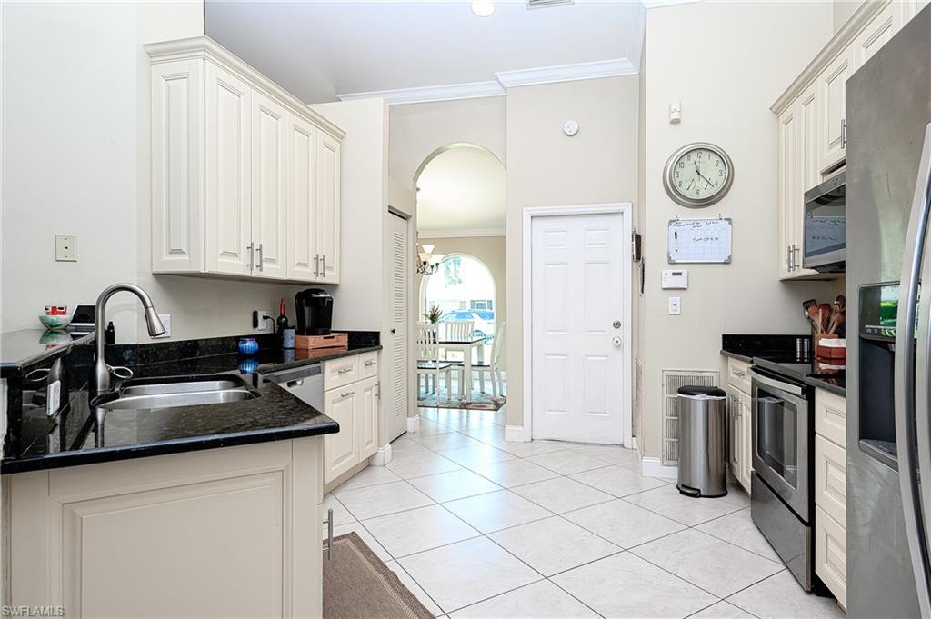 10058 Boca Circle Naples, FL 34109 - Photo 12 of 33 a kitchen with a sink cabinets and stainless steel appliances
