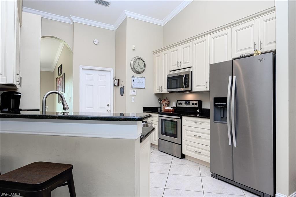 10058 Boca Circle Naples, FL 34109 - Photo 13 of 33 a kitchen with stainless steel appliances a refrigerator stove microwave and sink