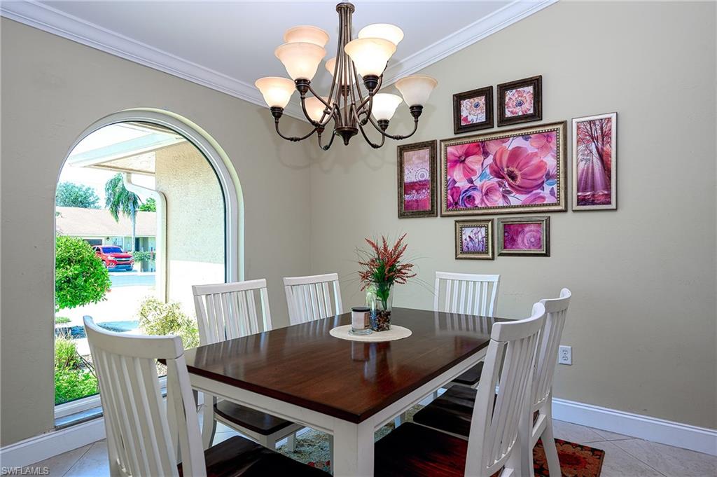 10058 Boca Circle Naples, FL 34109 - Photo 15 of 33 a view of a dining room with furniture a potted plant and wooden floor