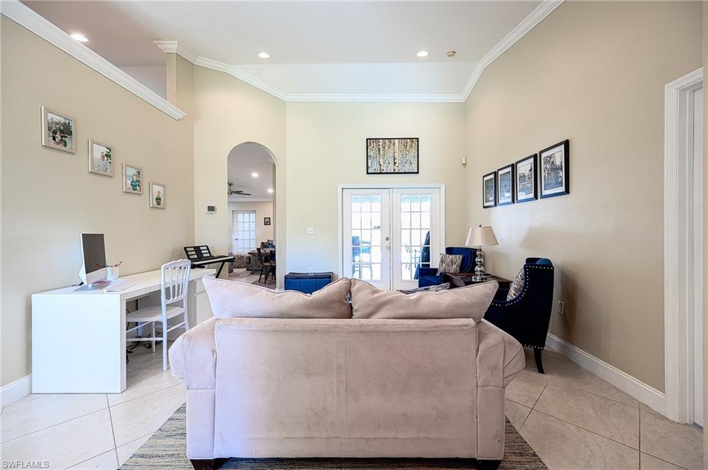 10058 Boca Circle Naples, FL 34109 - Photo 18 of 33 a living room with furniture a fireplace and a flat screen tv