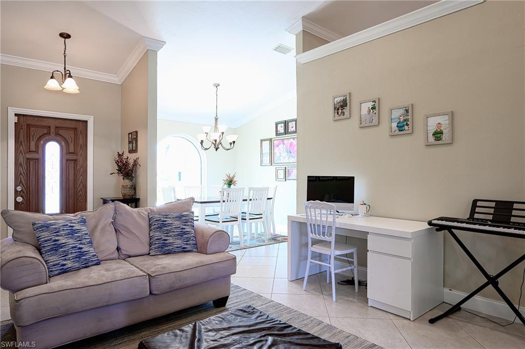 10058 Boca Circle Naples, FL 34109 - Photo 20 of 33 a living room with furniture a fireplace and a flat screen tv